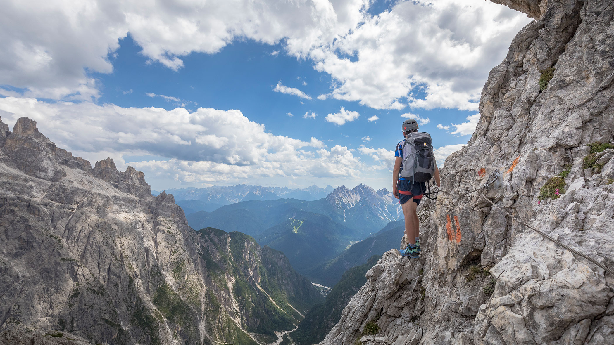 Ein Frau im Klettersteig genießt die Aussicht - Pustertaler Zeitung